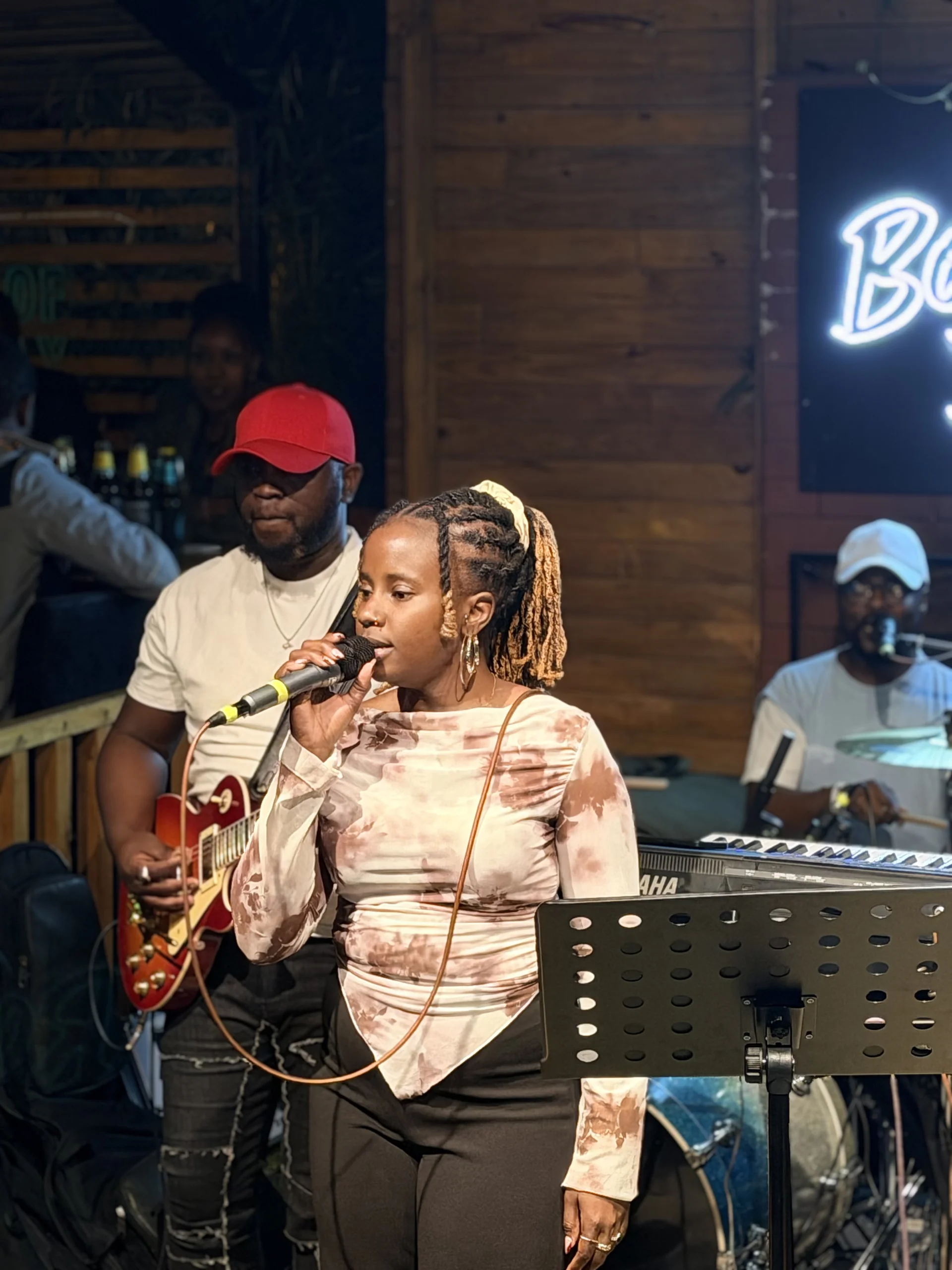 Vocalist singing into a microphone during a live Tone Blend Muzique performance